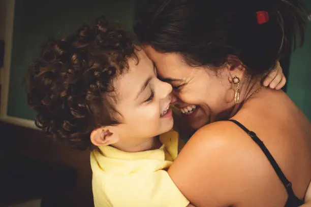 Mother and son embracing with love and smiling.