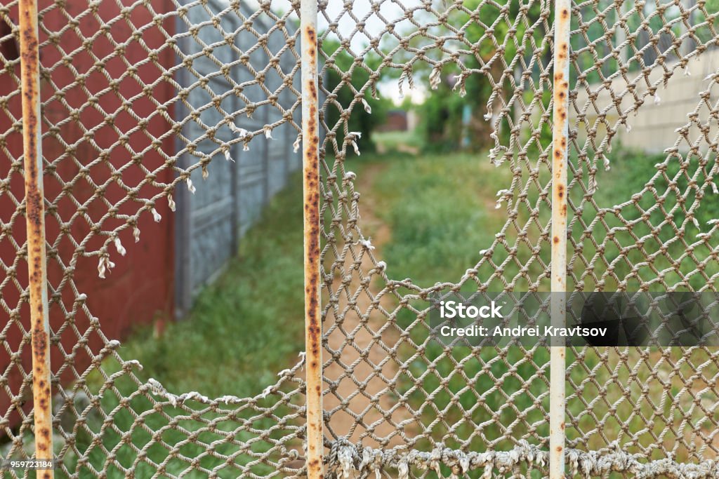 Ragged Rope Net Is On The Rusty Iron Fence Stock Photo - Download