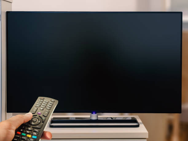 istock watching television with remote control at home. Blank tv screen 959724484