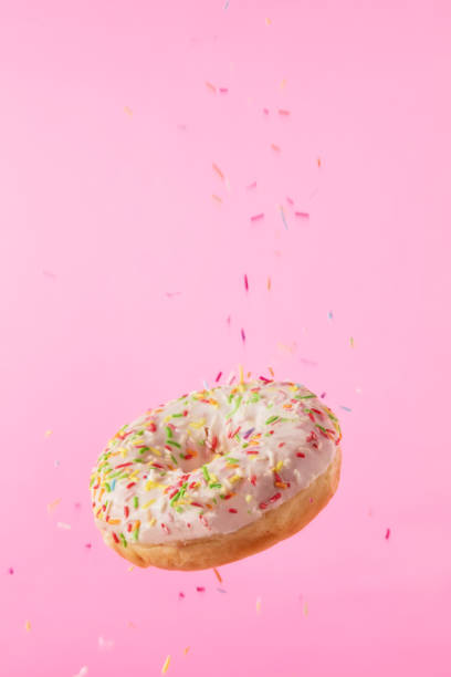 istock Flying sweet donut isolated on pink background 959724756