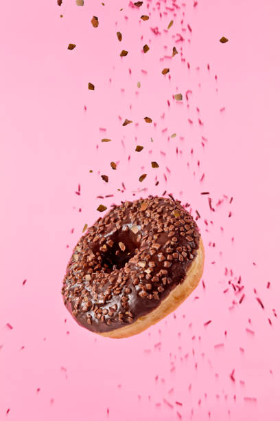 istock Flying sweet donut isolated on pink background. 959724782