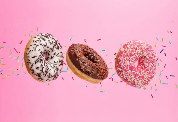 istock Flying sweet donuts isolated on pink background. 959724850