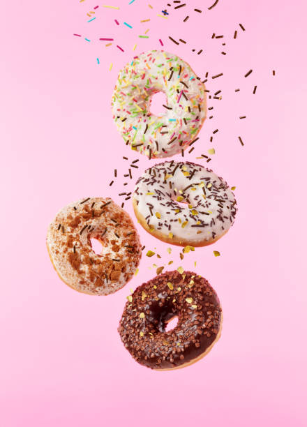 istock Flying sweet donuts isolated on pink background. 959724884