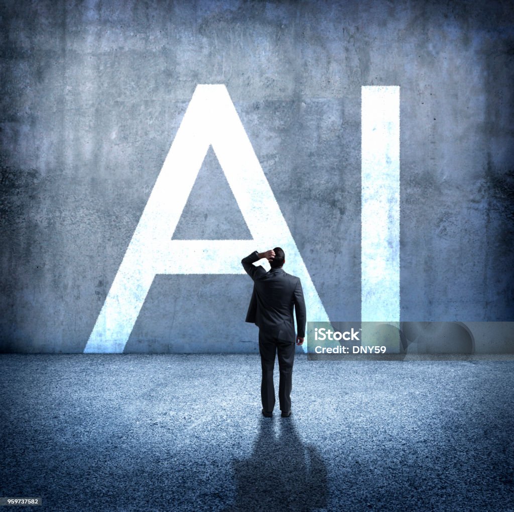 Man Concerned By Implications Of Artificial Intelligence A rear view of a man standing with his hand on top of his head as he stands below the large letters, "AI" which stand for artificial intelligence.  He is concerned about the unknown implications of the rollout of artificial intelligence on our society. Artificial Intelligence Stock Photo