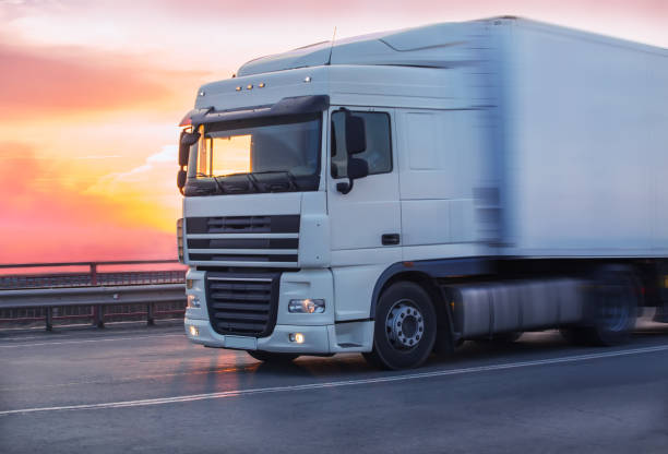 istock truck goes on highway on sunset 959741060