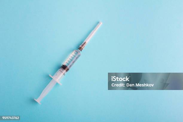 Syringe With Lid On Blue Background Stock Photo - Download Image Now - High Angle View, Injecting, Syringe