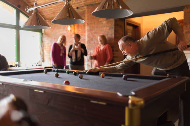 un grupo de amigos jugando al billar en un bar - pool hall fotografías e imágenes de stock