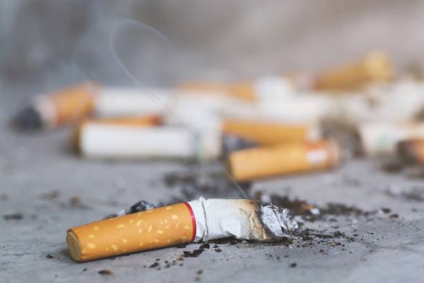 smoking a cigarette. pulverize the floor. light and smoke smoking a cigarette. pulverize the floor. light and smoke cigarette fire stock pictures, royalty-free photos & images