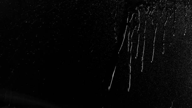 Raindrops of white water on glass. Perfect for digital composing. Pure black background.