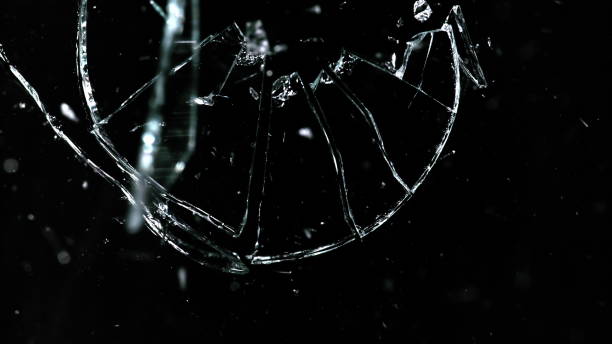 istock Shattered and broken glass pieces isolated on black 959749334