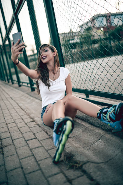 istock Smiling Young Girl Taking Selfie During RollerBlading in Skate Park 959752360