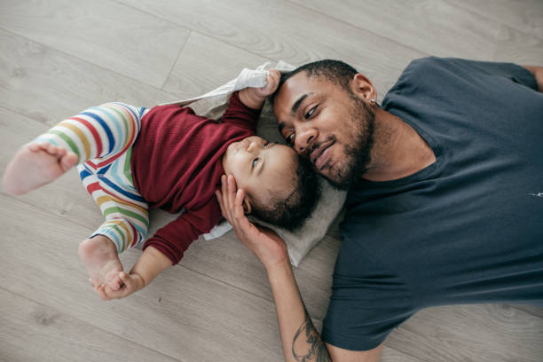 Growth spurt Father and daughter relaxing on the floor. father and baby stock pictures, royalty-free photos & images