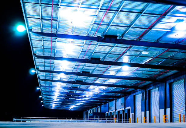 Industrial Warehouse at Night Exterior view of a modern industrial warehouse in a business park industrial style photos stock pictures, royalty-free photos & images