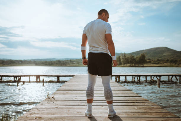 istock Young man exercising by the lake 959766060