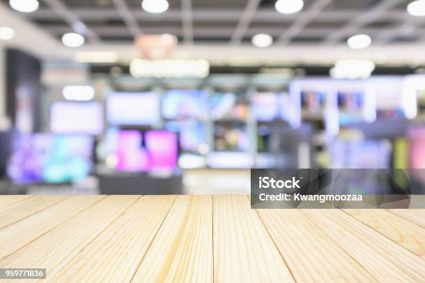Wood Table Top With Eletronic Department Store Show Television Tv And Home Appliance With Bokeh Light Blurred Background Stock Photo - Download Image Now