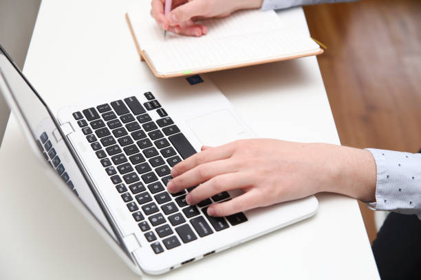 istock Close up of a person using white laptop at home office 959775842