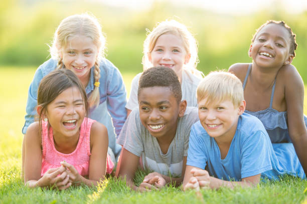 istock Happy Kids Laying In Grass 959779252