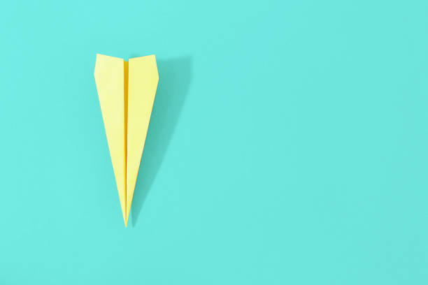 istock Top view creative travel background concept. Flat lay yellow paper plane on pastel background with copy space 959779864