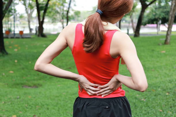 istock Healthy athlete suffering from back injury during run in the park. 959782616