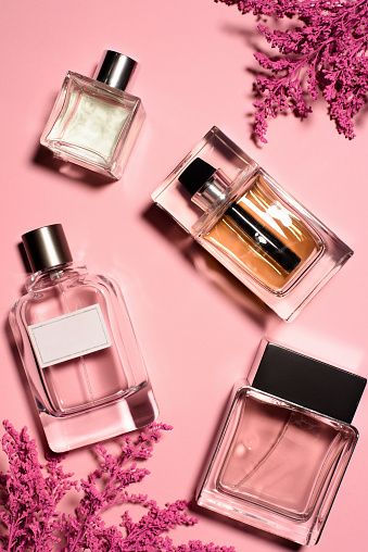 top view of bottles of perfumes with pink flowers