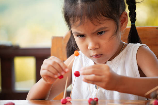 menina bonita criança asiática brincando e criando com massinha e palito - skill child mathematics physics - fotografias e filmes do acervo