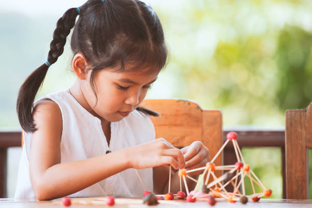 menina bonita criança asiática brincando e criando com massinha e palito - skill child mathematics physics - fotografias e filmes do acervo