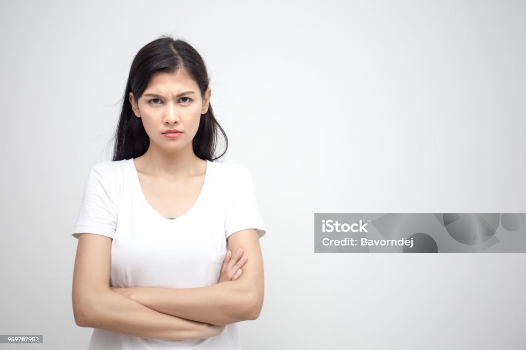 Young asian woman looking to camera with angry emotion. Isolated on white background. Anger Stock Photo