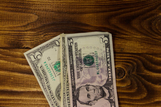 istock Five dollars banknotes on wooden background. Top view 959792340
