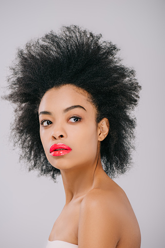 beautiful young woman with red lips and afro hairstyle isolated on grey