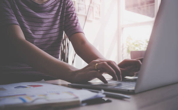 istock Business woman is using computer on wooden table with financial accounting objects 959796942
