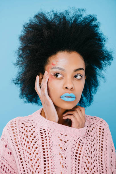 istock beautiful young woman with creative makeup in sweater on blue 959798320