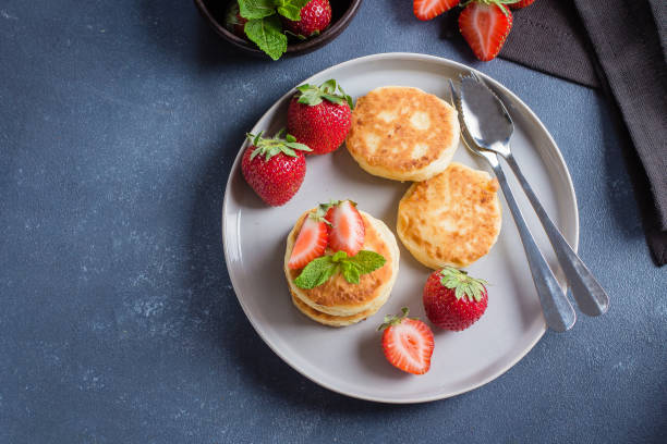 istock Cottage cheese pancakes with strawberry on blue concrete table background. Breakfast or Lunch Concept. Top view, copy space 959798608