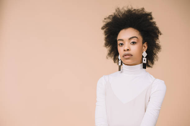 istock attractive young woman in white turtleneck looking at camera isolated on beige 959803524
