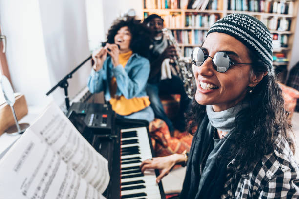 istock Young woman playing piano with friends 959811290