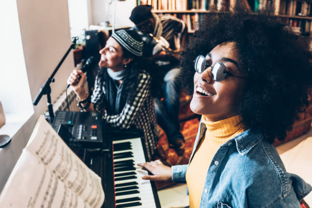 istock Woman singing and playing the piano in studio 959811292