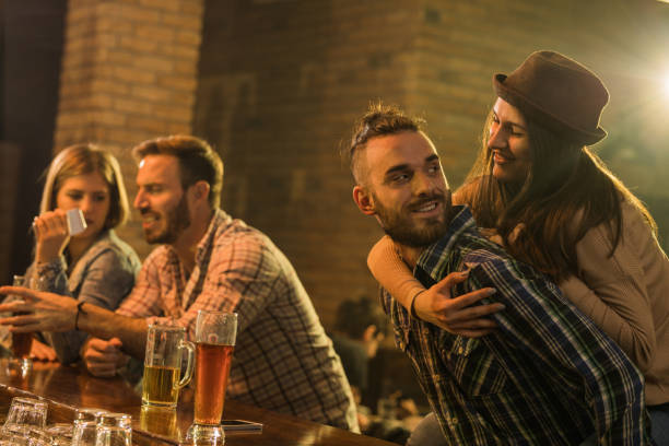 istock Playful couple having fun during the night out in a pub. 959815536