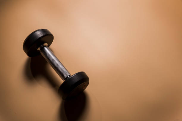 istock Gym equipment dumbbell on yellow background 959823244