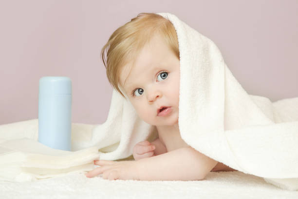 adorável bebê coberto com toalha de banho, estúdio tiro - baby cheerful child blanket - fotografias e filmes do acervo