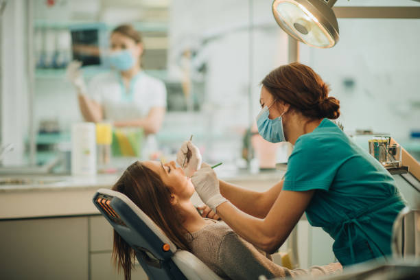 istock Young woman having her teeth checked during appointment at dentist's office. 959832316