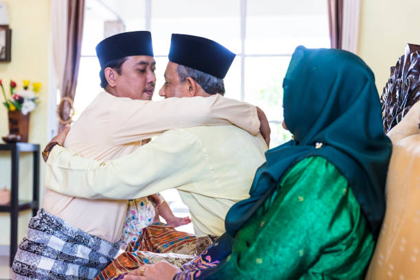 Father and Son hugging each other during a festive celebration Hari Raya celebration at home with the family hari raya family stock pictures, royalty-free photos & images