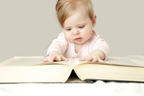 istock Adorable baby in front of big thick book, studio shot 959833092