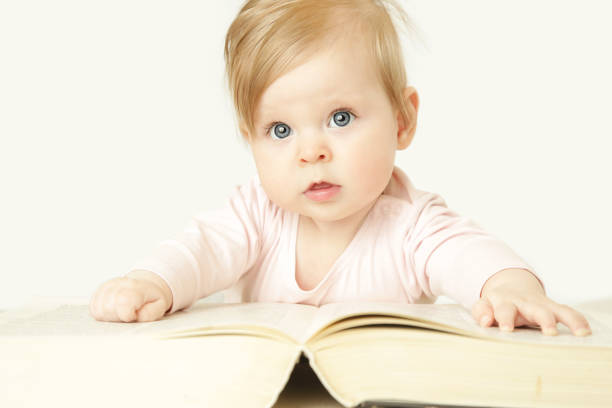 istock Adorable baby in front of big thick book, studio shot 959833106