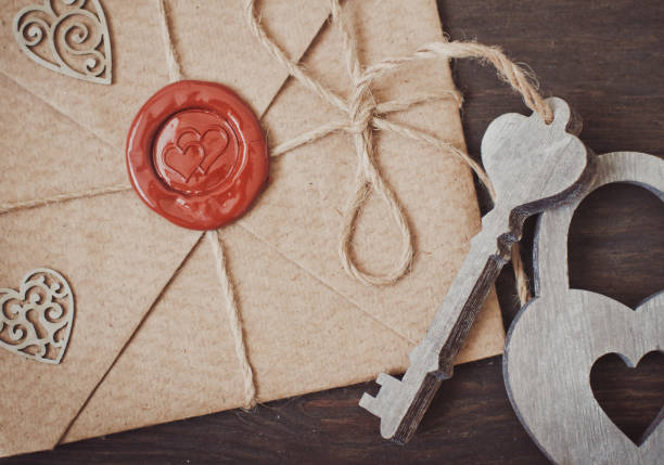 love letter in a craft envelope with a sealing wax seal in the form of a heart on a wooden background. Free space