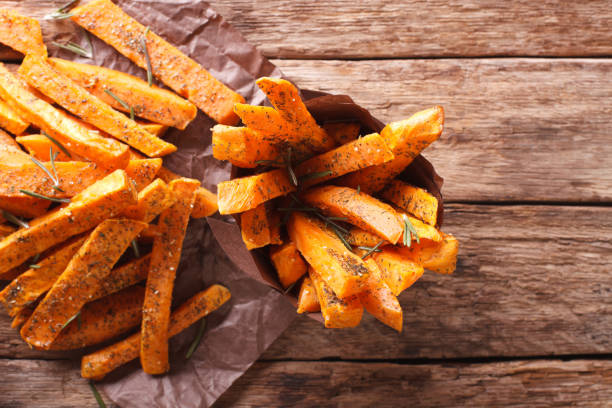 istock roasted sweet potatoes with herbs in a paper cone close-up. Horizontal top view 959838310
