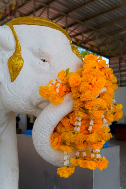istock The elephant's sculpture is decorated with orange flowers. 959843578