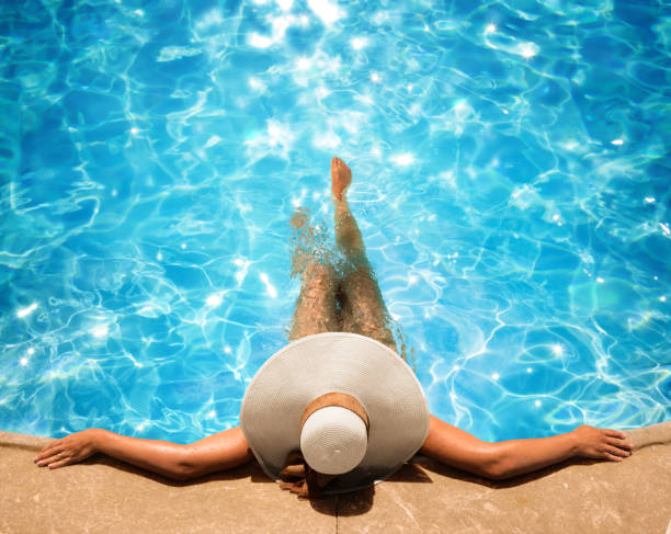 mujer relajante en la piscina - albercas fotografías e imágenes de stock