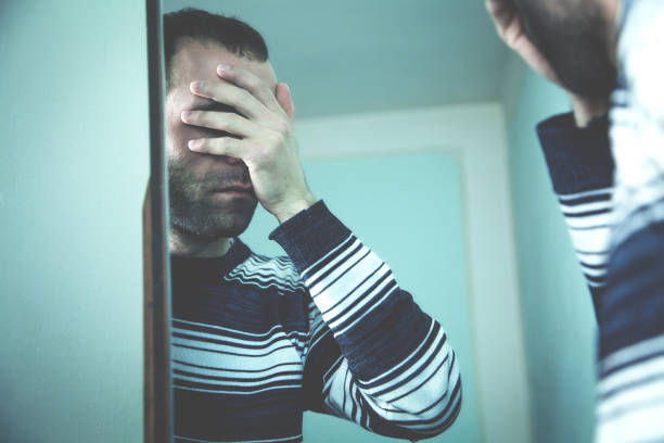istock Man standing before the mirror and closed his face. 959844260