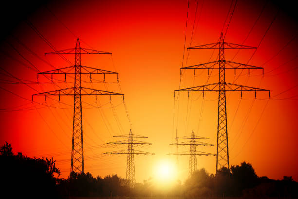 Electricity industry high voltage towers in a row at sun set
