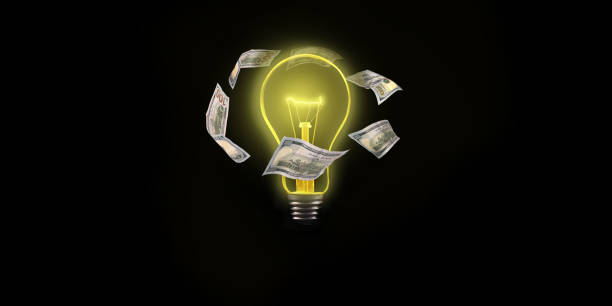 istock Light bulb with flying dollar bills on the outside on a black background 959856134