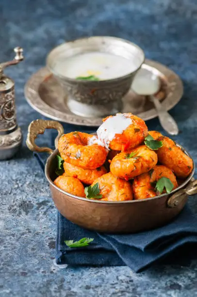 Traditional Turkish food - fellah koftes, polpettes from bulgur and semolina in tomato sauce with parsley and ayran. Middle eastern food concept.